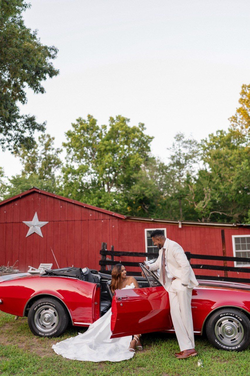 By the red convertible at the barn